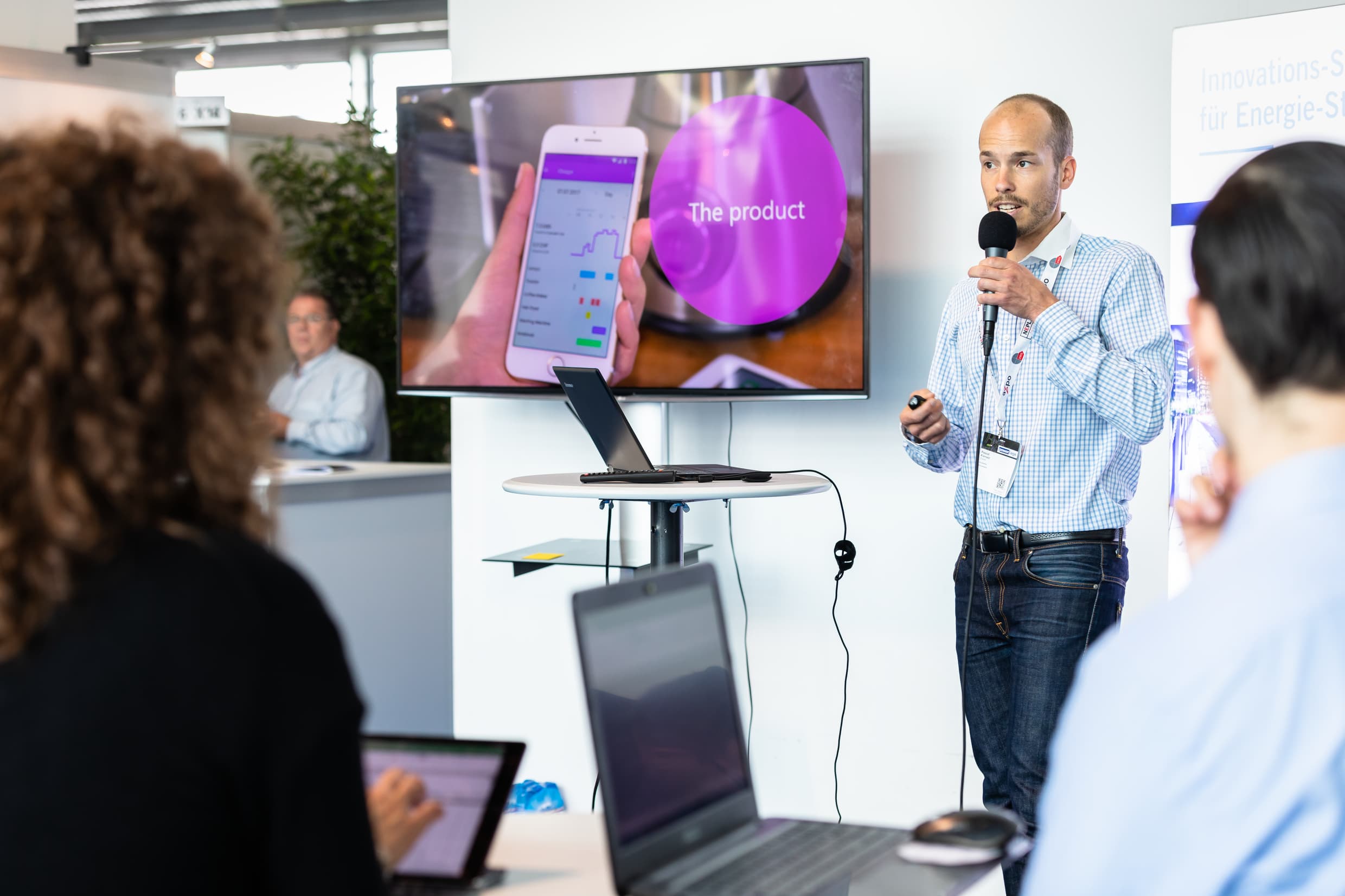 A presendator speaks into a microphone at xplor startup village.